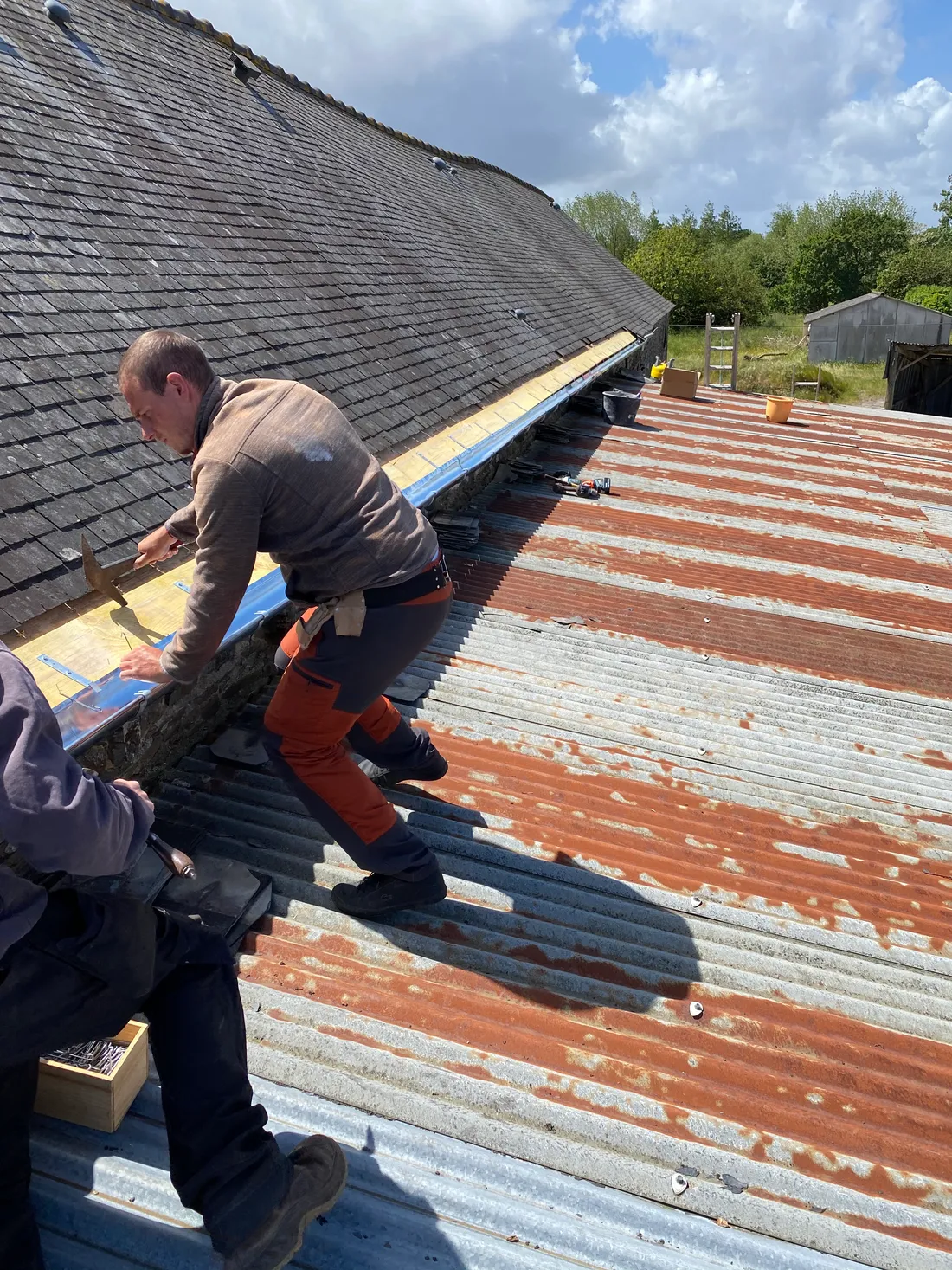 Chantier de pose neuve d'ardoises naturelles sur une architecture typique